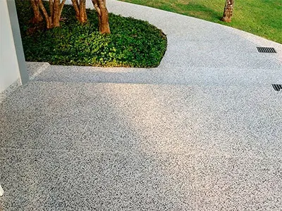 Calçada externa residencial em granilha com jardim ao lado